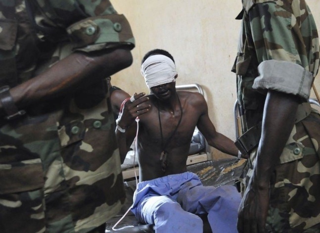 Des rebelles du Séléka parlent, le 29 mars 2013, avec l'un des leurs soigné dans un hôpital de Bangui | Photo : Agence France-Presse Sia Kambou