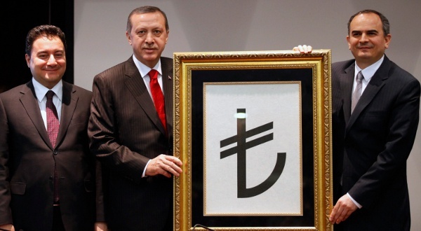 Recep Tayyip Erdogan, entouré du vice-Premier ministre Ali Babacan et du gouverneur de la Banque centrale Erdem Basci, présente le symbole de la monnaie turque, le 1er mars 2012 | Crédit Photo -- Umit Bektas/Reuters