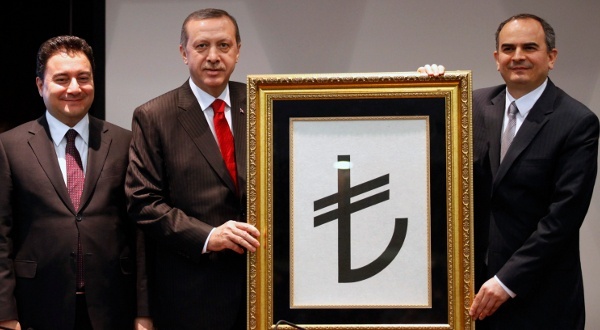 Recep Tayyip Erdogan, entouré du vice-Premier ministre Ali Babacan et du gouverneur de la Banque centrale Erdem Basci, présente le symbole de la monnaie turque, le 1er mars 2012 | Crédit Photo -- Umit Bektas/Reuters Recep Tayyip Erdogan, entouré du vice-Premier ministre Ali Babacan et du gouverneur de la Banque centrale Erdem Basci, présente le symbole de la monnaie turque, le 1er mars 2012 | Crédit Photo -- Umit Bektas/Reuters