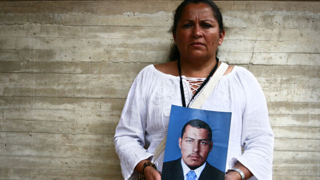 Mãe mostra o retrato de seu filho assassinado pelo exército. Créditos: Emma Gascó