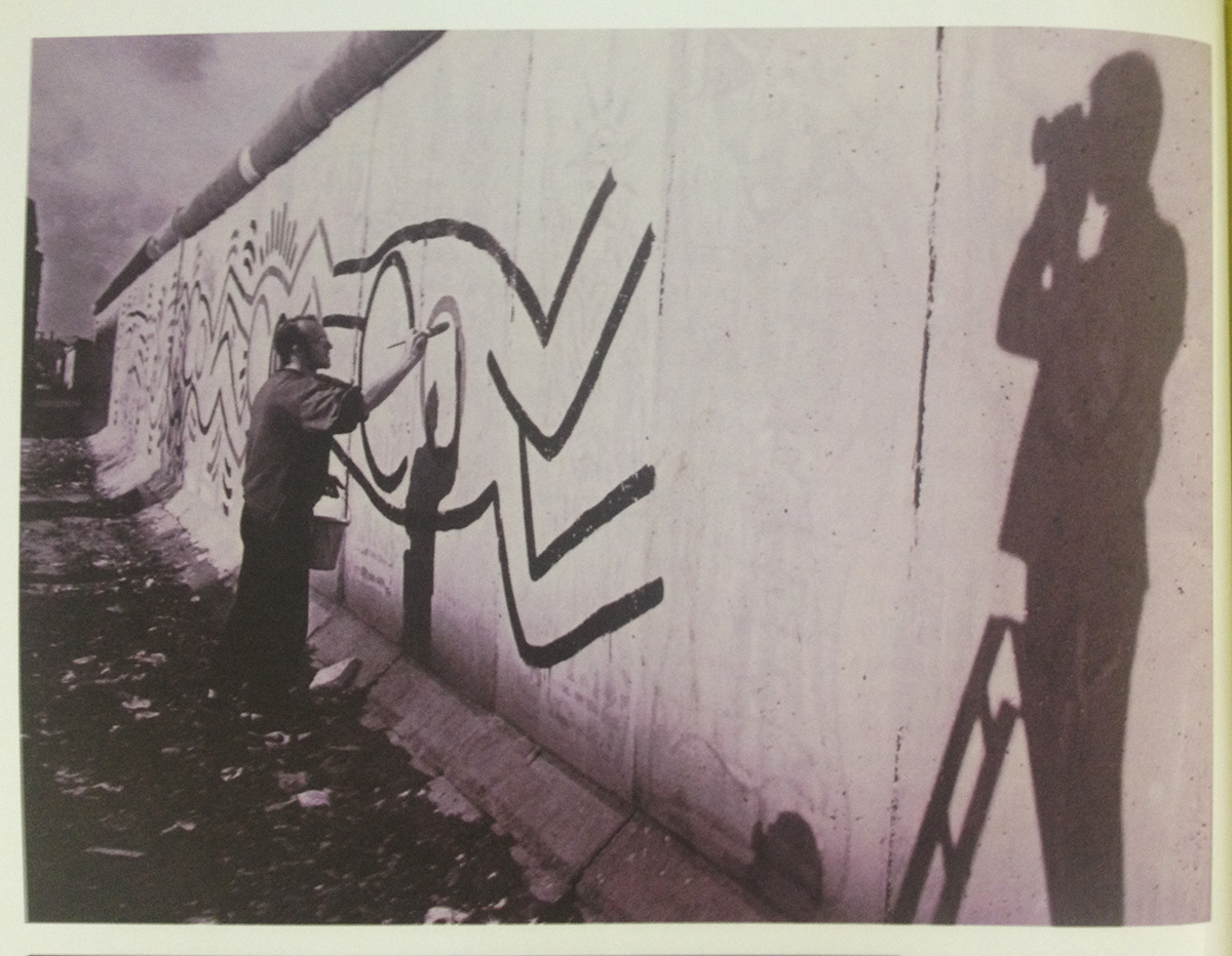 Image d’archive : Thierry Noir, peignant le Mur de Berlin en 1984 -  Photo issue du Livre B-Movie Lust & Sound, de Mark Reeder, Berlin 2015