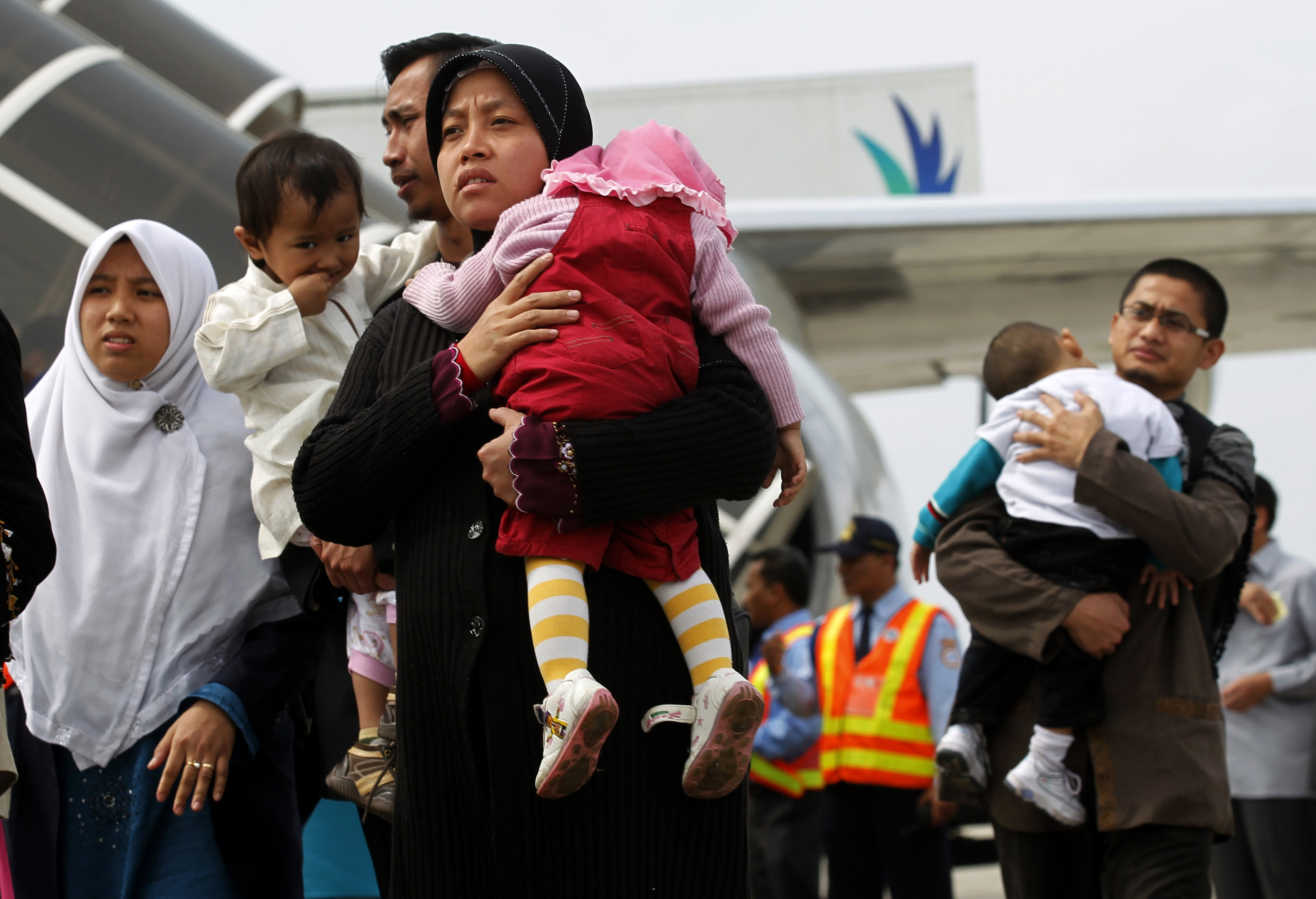 A group of Indonesian migrant workers and their families at an airport, protected by government regulations and standards.