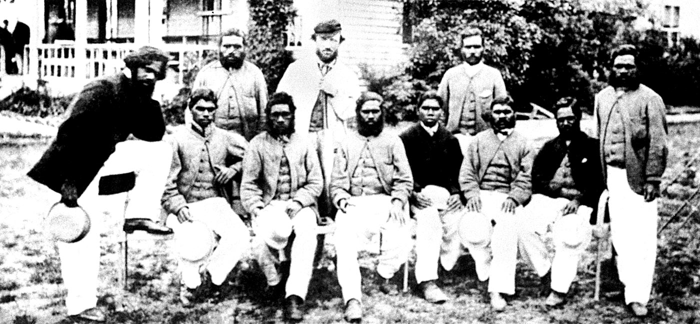 Tom Wills, reconnaissable à sa casquette, debout au second rang, entouré des aborigènes qui composaient son équipe de cricket – Crédit Wikimedia Commons