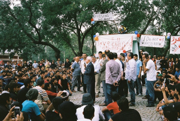 On the banners, calls to open the borders are written in English, German and French. Below, the governor is rising up. Credits to G.M.