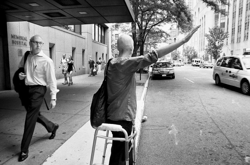 Jen hailing a cab outside of hospital